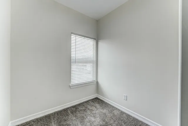 a bathroom with a granite countertop sink vanity mirror and toilet