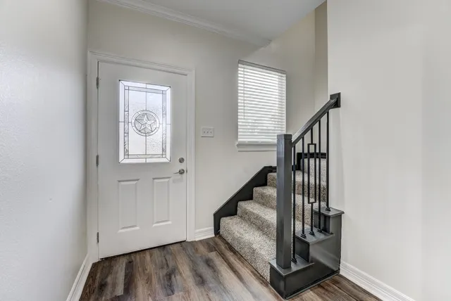 a view of entryway and hall with wooden floor