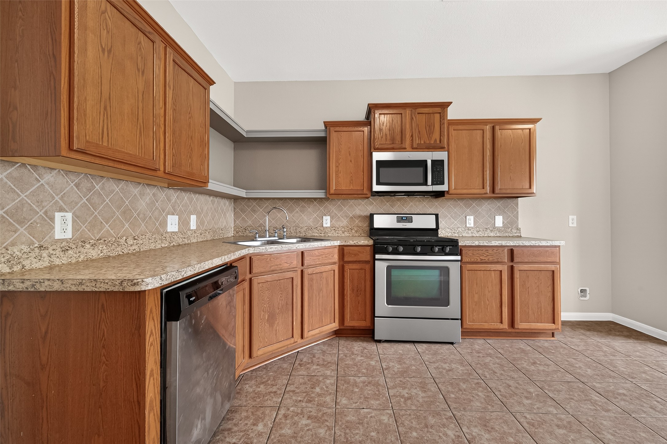 21327 Bella Flora Court Spring, TX 77379 - Photo 17 of 50 a kitchen with granite countertop a stove top oven microwave and cabinets