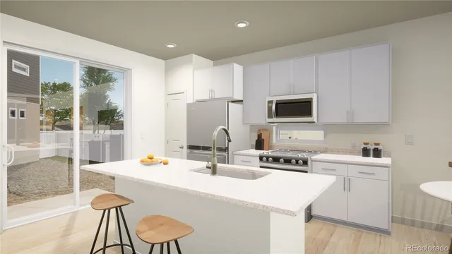 a kitchen with stainless steel appliances a sink a stove a refrigerator cabinets and a dining table with wooden floor