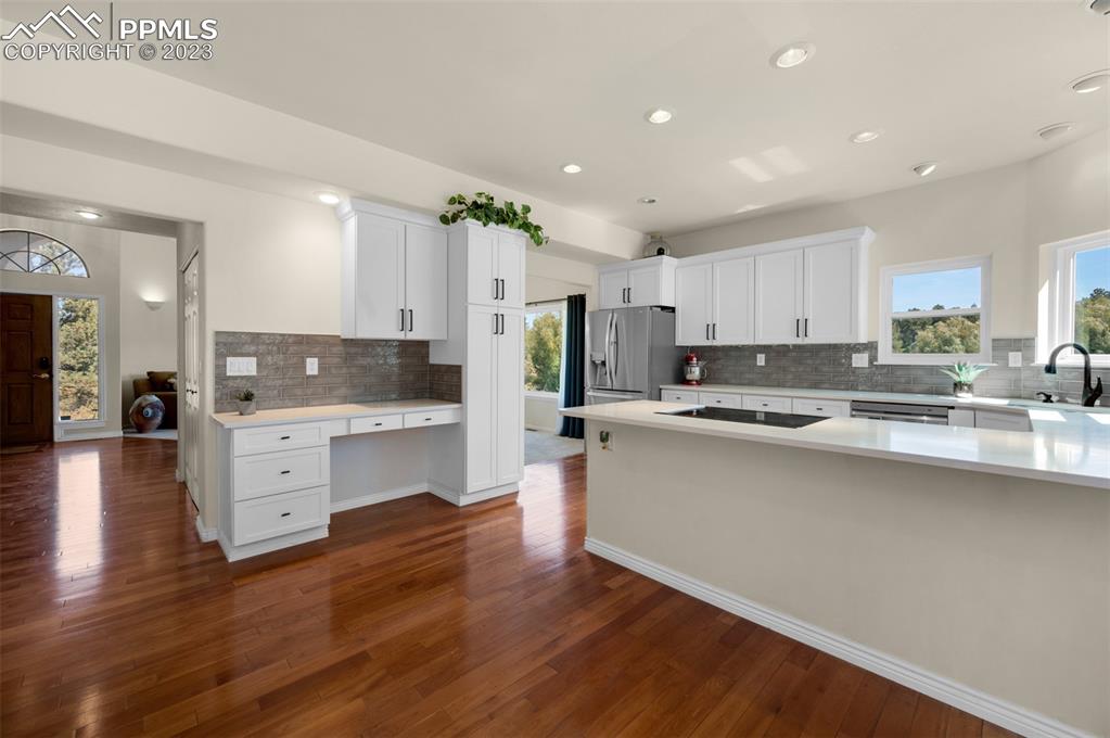 7425 Tobin Road Colorado Springs, CO 80908 - Photo 18 of 49 a large kitchen with cabinets a sink a window and stainless steel appliances