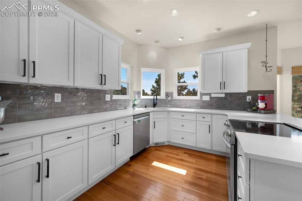 7425 Tobin Road Colorado Springs, CO 80908 - Photo 20 of 49 a kitchen with granite countertop white cabinets white appliances and sink