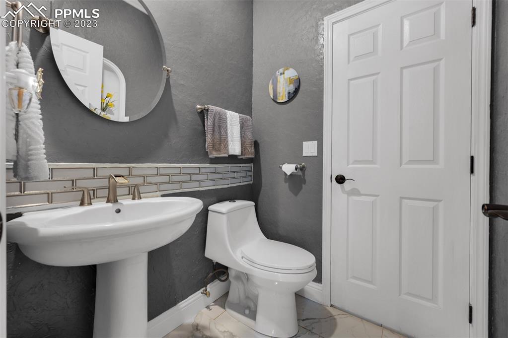 7425 Tobin Road Colorado Springs, CO 80908 - Photo 22 of 49 a bathroom with a toilet sink and mirror