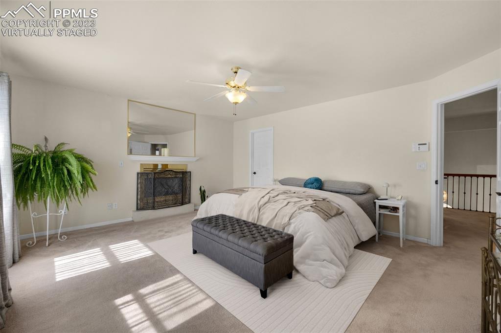 7425 Tobin Road Colorado Springs, CO 80908 - Photo 29 of 49 a spacious bedroom with a bed a chandelier and window
