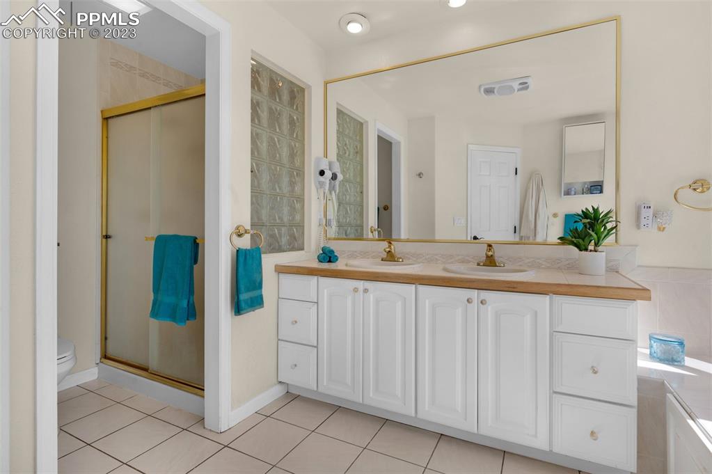 7425 Tobin Road Colorado Springs, CO 80908 - Photo 31 of 49 a bathroom with a double vanity sink and a mirror