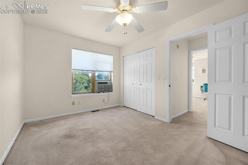 7425 Tobin Road Colorado Springs, CO 80908 - Photo 37 of 49 an empty room with chandelier fan and windows