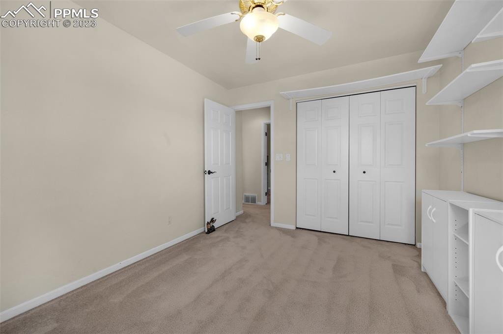 7425 Tobin Road Colorado Springs, CO 80908 - Photo 39 of 49 wooden floor in an empty room with a chandelier fan