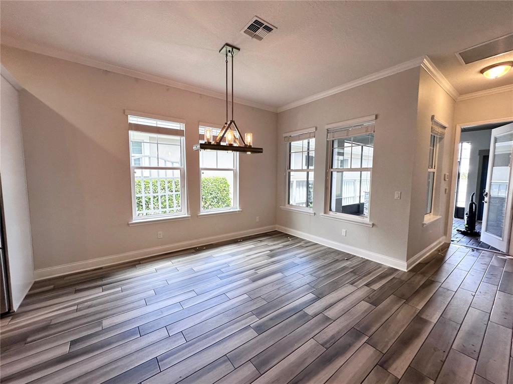 9319 Richet Place Orlando, FL 32827 - Photo 11 of 50 a view of an empty room with wooden floor fridge and a window