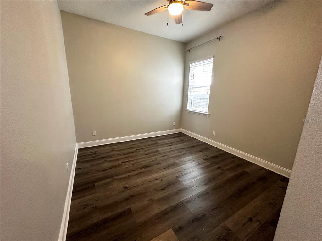 9319 Richet Place Orlando, FL 32827 - Photo 13 of 50 an empty room with wooden floor and windows