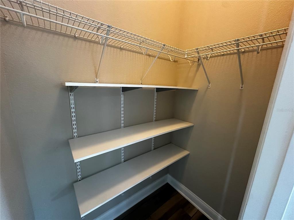 9319 Richet Place Orlando, FL 32827 - Photo 15 of 50 a view of walk in closet with clothes and shoes