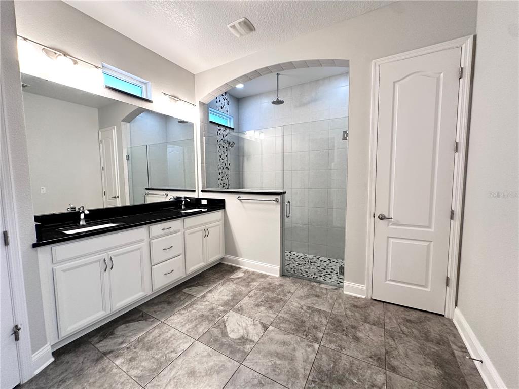 9319 Richet Place Orlando, FL 32827 - Photo 22 of 50 a large bathroom with a double vanity sink and a mirror