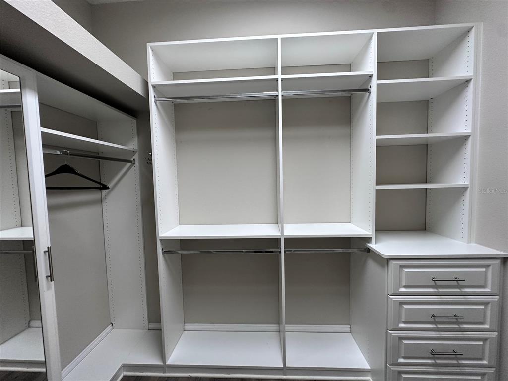 9319 Richet Place Orlando, FL 32827 - Photo 25 of 50 a view of walk in closet with empty racks