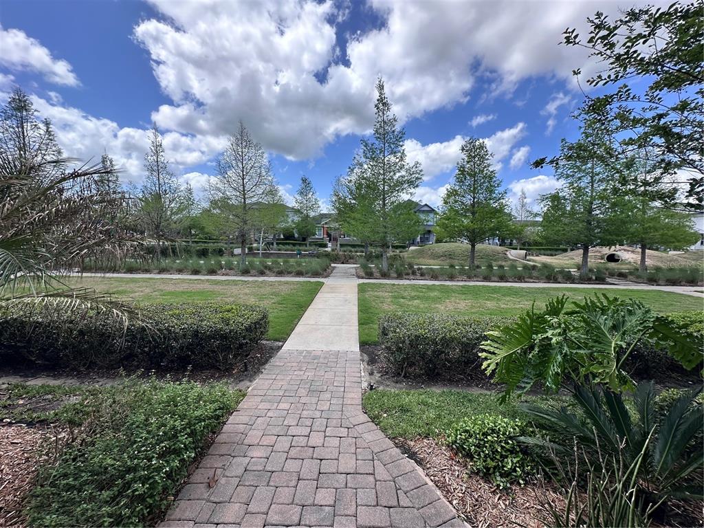 9319 Richet Place Orlando, FL 32827 - Photo 26 of 50 a view of a garden with a lake