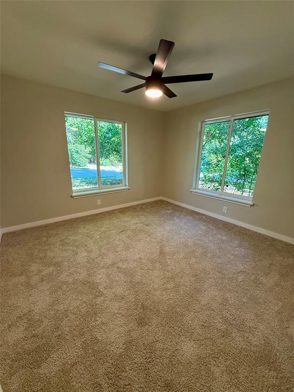 4815 Kelman Street Dallas, TX 75214 - Photo 14 of 16 Empty room featuring baseboards and light carpet