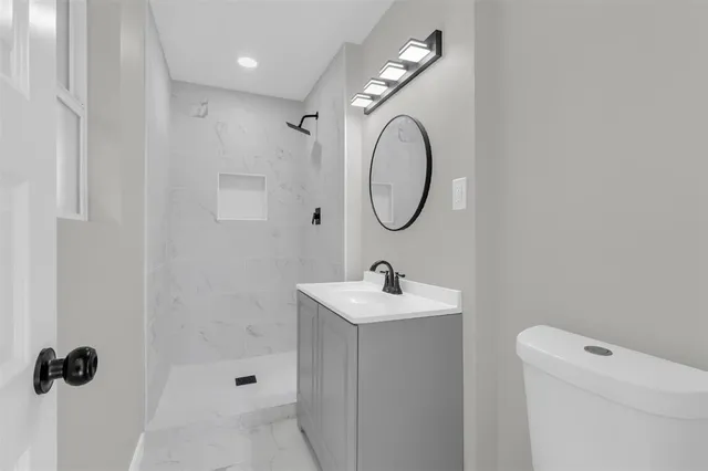 a bathroom with a sink a toilet and shower