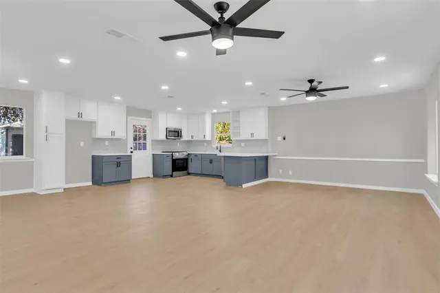 a view of a kitchen with a sink and a stove top oven with kitchen island