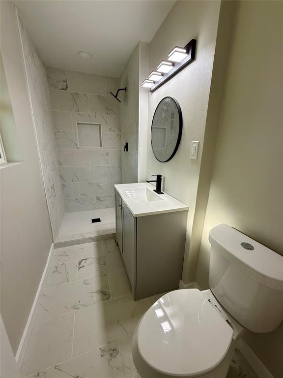 4815 Kelman Street Dallas, TX 75214 - Photo 8 of 16 Full bathroom featuring vanity, a shower stall, and light marble finish flooring