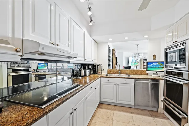 a kitchen with stainless steel appliances granite countertop a stove sink and cabinets