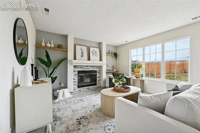 a living room with furniture a large window and a fireplace