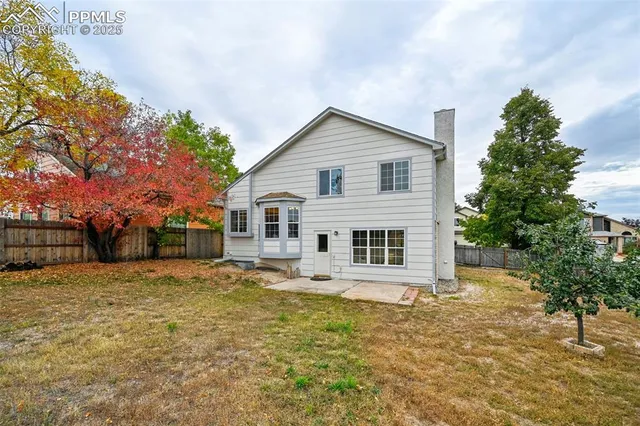 a white house with a large tree in front of it