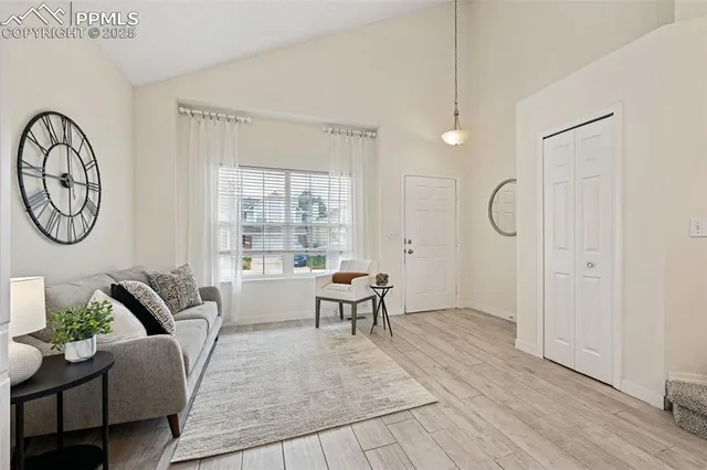 a living room with furniture a clock and a window