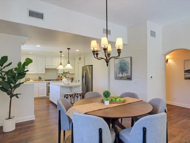 a dining room with furniture potted plants and wooden floor