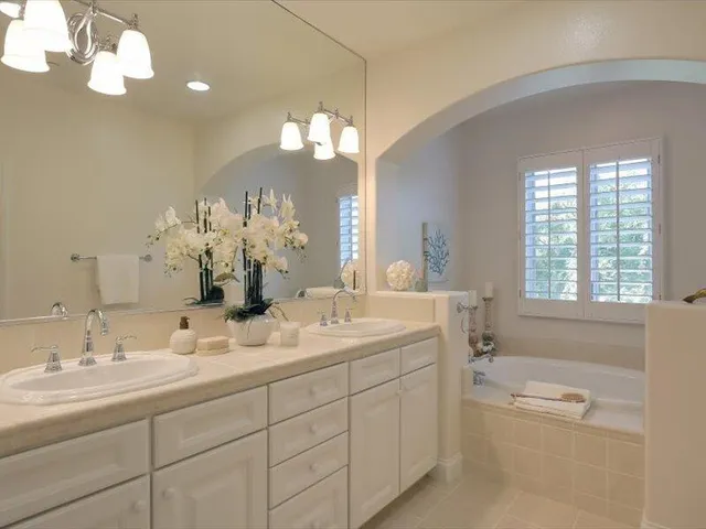 a bathroom with a sink mirror and a shower