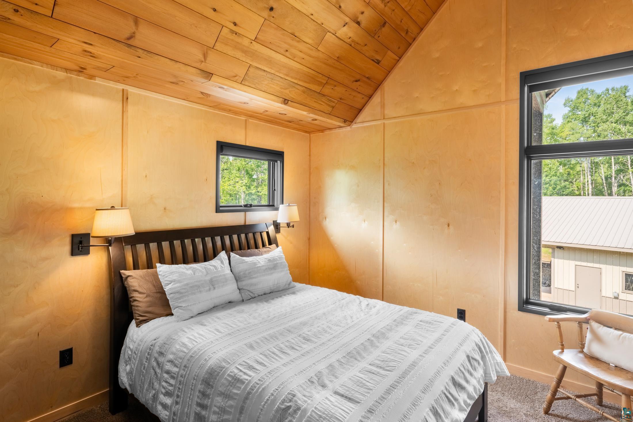 3778 East County Road Barnum, MN 55707 - Photo 41 of 52 Wood-paneled vaulted ceiling, natural wood-finish wall panels, and black-framed windows