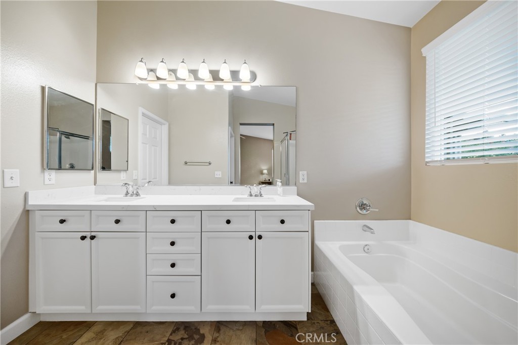 40889 Robards Way Murrieta, CA 92562 - Photo 19 of 36 a bathroom with a sink double vanity granite tub and a mirror