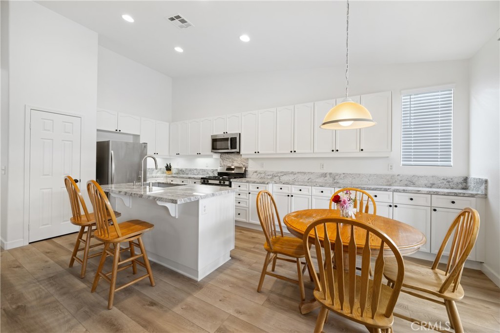 40889 Robards Way Murrieta, CA 92562 - Photo 3 of 36 a kitchen with a dining table chairs and white cabinets