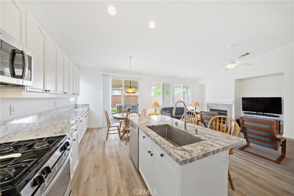 40889 Robards Way Murrieta, CA 92562 - Photo 4 of 36 a kitchen with stainless steel appliances granite countertop a sink stove and microwave