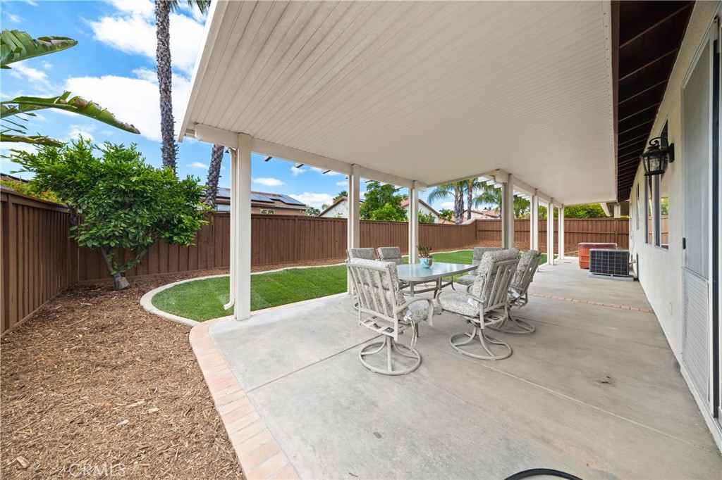 40889 Robards Way Murrieta, CA 92562 - Photo 6 of 36 a view of a patio with table and chairs potted plants with wooden fence