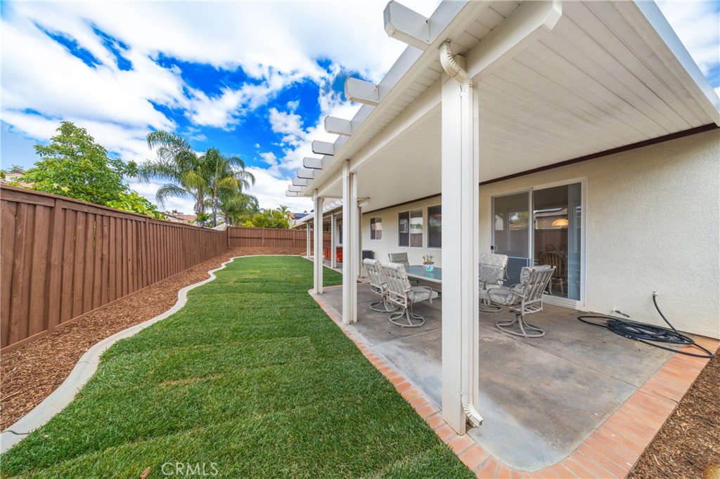 40889 Robards Way Murrieta, CA 92562 - Photo 7 of 36 a view of a backyard with table and chairs and wooden fence
