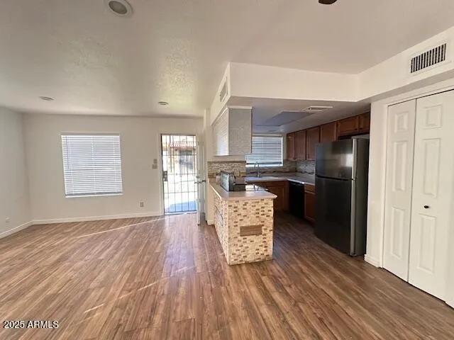 a kitchen with stainless steel appliances granite countertop a refrigerator and a stove top oven