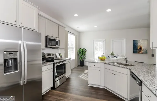 a kitchen with a sink stainless steel appliances and white cabinets