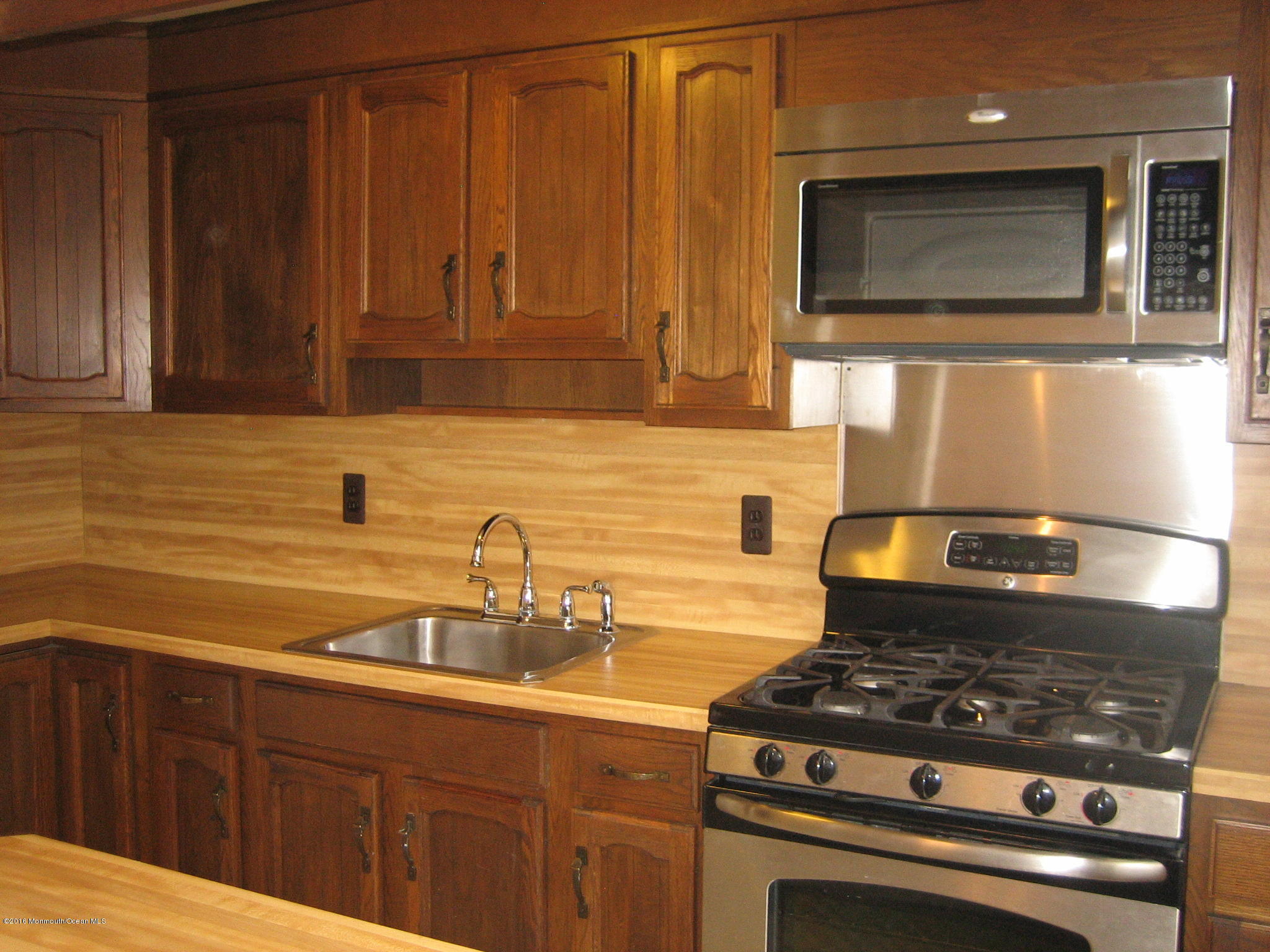 169 Manor Drive Red Bank, NJ 07701 - Photo 5 of 12 a kitchen with granite countertop a stove top oven microwave and cabinets