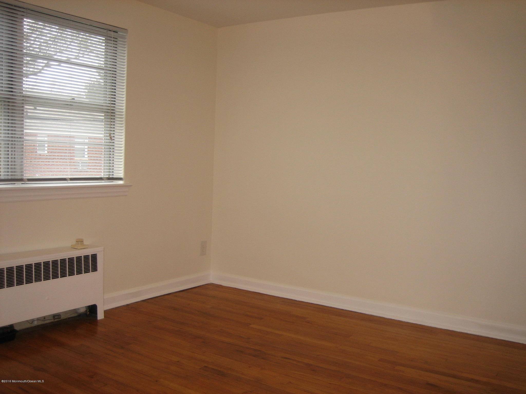 169 Manor Drive Red Bank, NJ 07701 - Photo 8 of 12 a view of an empty room with wooden floor and a window