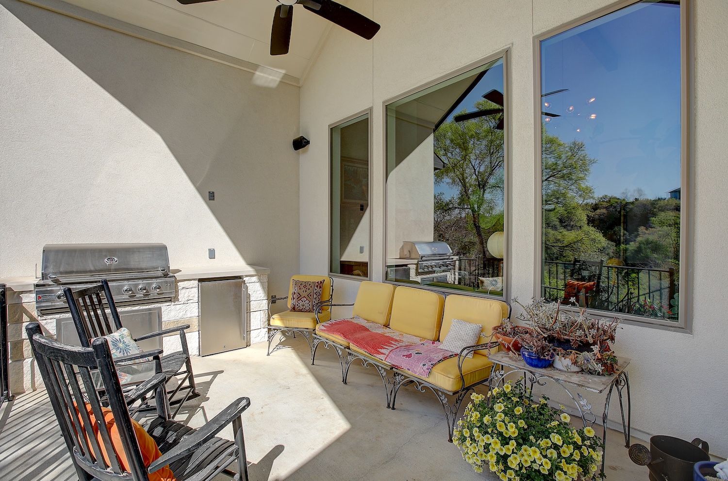129 Hollytree Court Georgetown, TX 78628 - Photo 3 of 40 This lovely back porch features a gorgeous view, an outdoor kitchen, a ceiling fan, and plenty of space for entertaining.