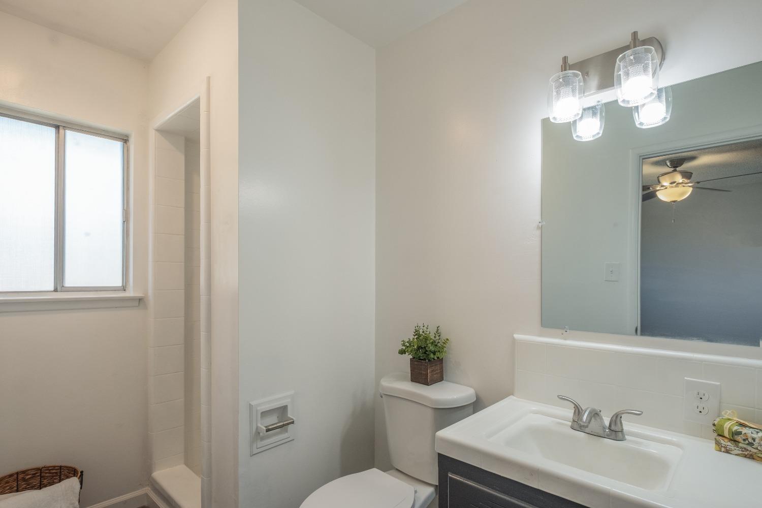 194 West Spring Lane Lemoore, CA 93245 - Photo 11 of 15 a bathroom with a sink vanity granite toilet and a mirror