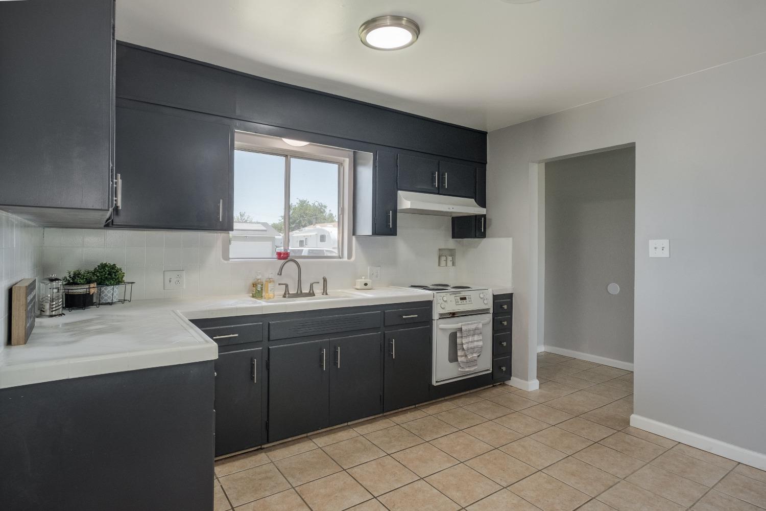 194 West Spring Lane Lemoore, CA 93245 - Photo 5 of 15 a kitchen with stainless steel appliances granite countertop a sink stove and refrigerator