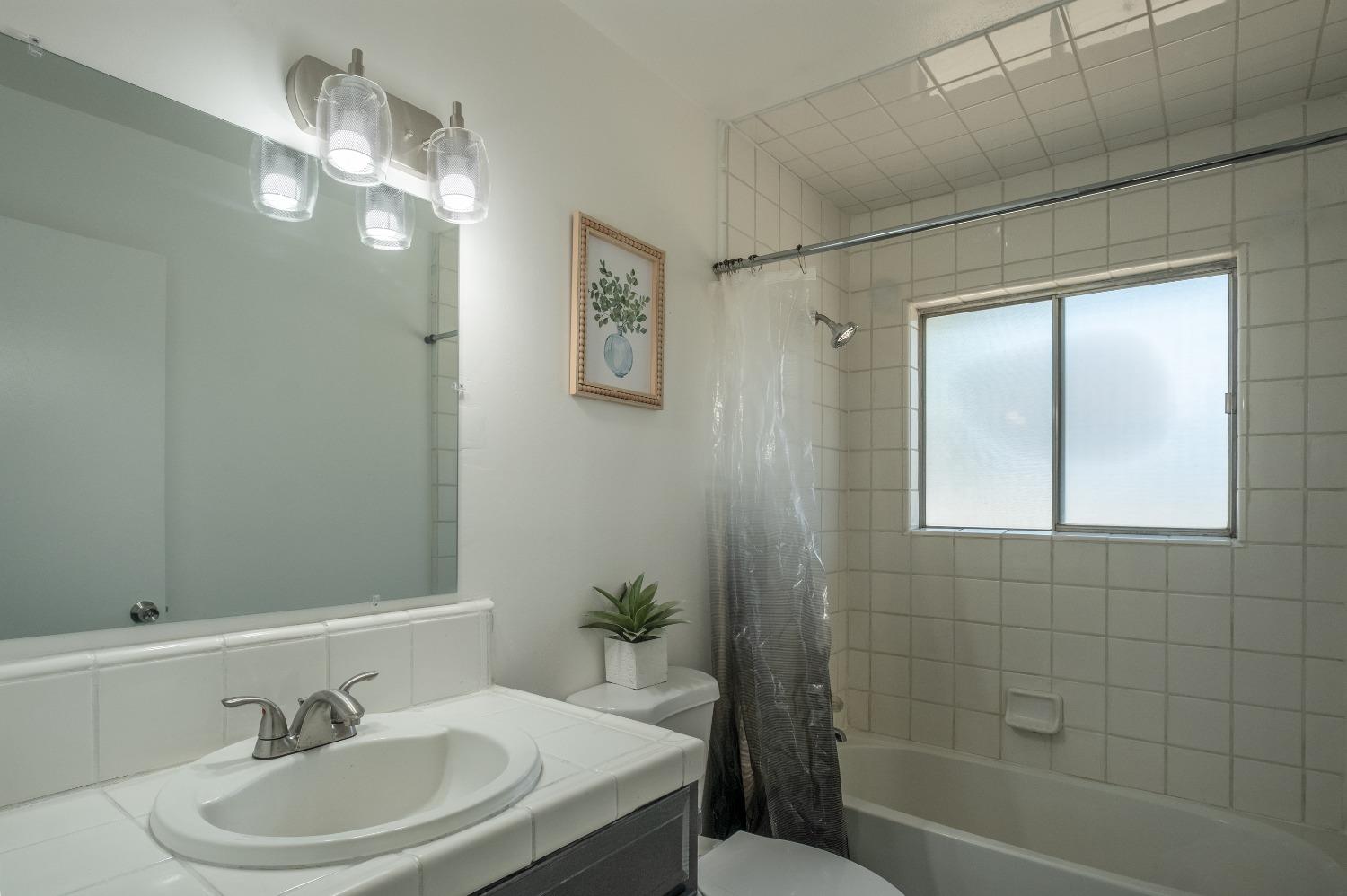 194 West Spring Lane Lemoore, CA 93245 - Photo 7 of 15 a bathroom with a sink a toilet and shower
