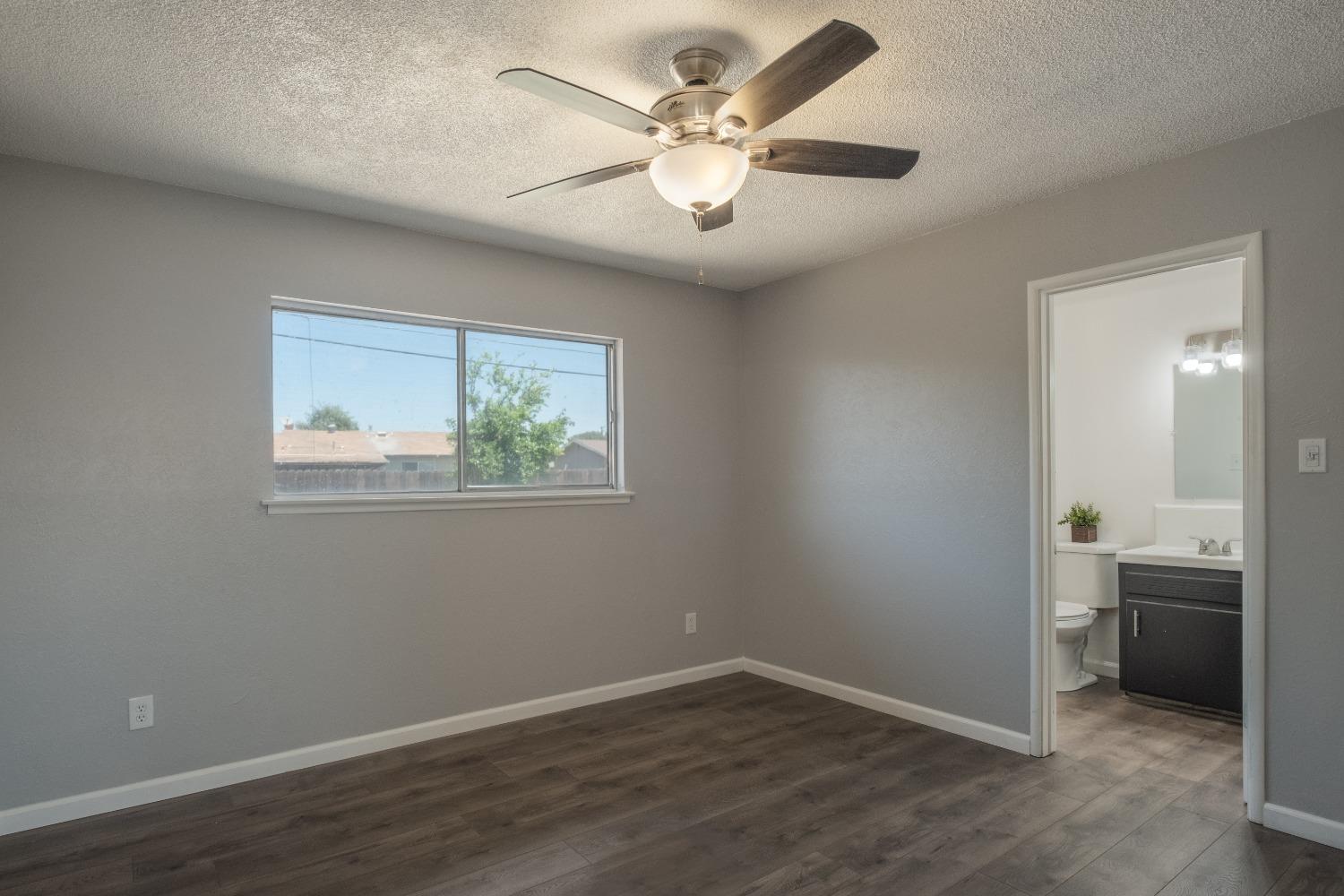 194 West Spring Lane Lemoore, CA 93245 - Photo 10 of 15 a view of an empty room with a window and wooden floor