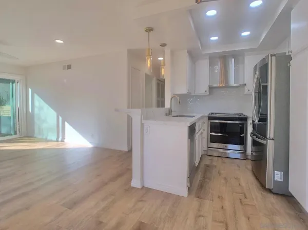 a kitchen with stainless steel appliances a stove a sink a refrigerator and a oven