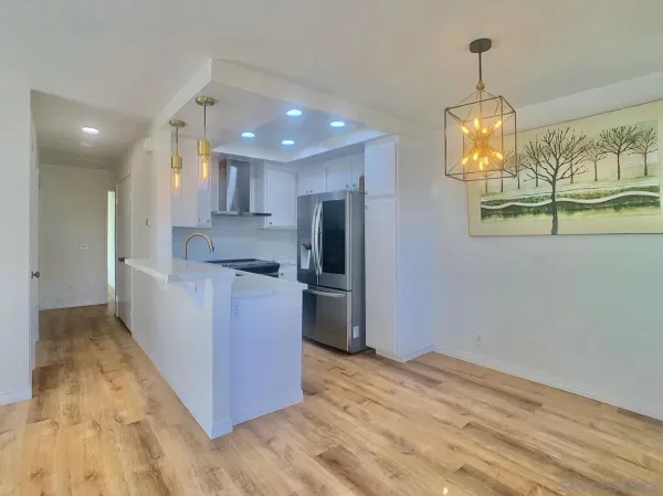 a kitchen with stainless steel appliances granite countertop a refrigerator and a stove top oven