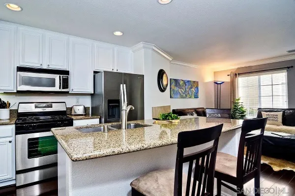 a kitchen with granite countertop kitchen island a table and chairs in it