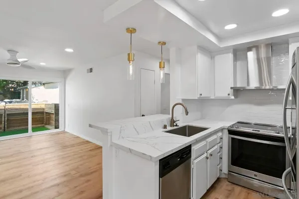 a kitchen that has a sink a stove and cabinets