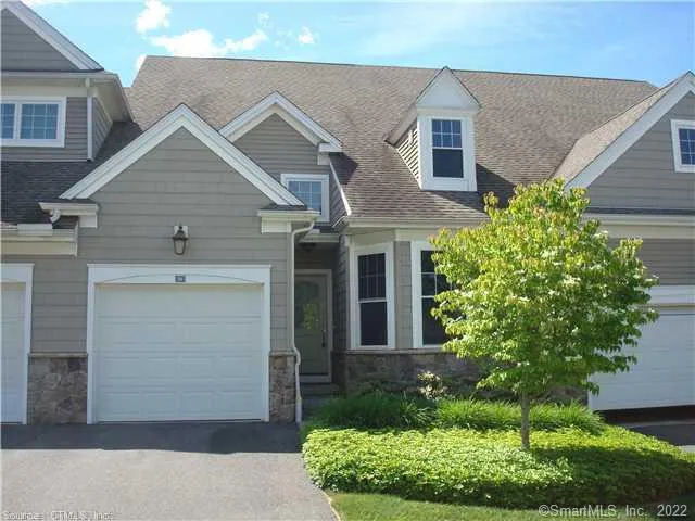 a front view of a house with a yard garage and outdoor seating