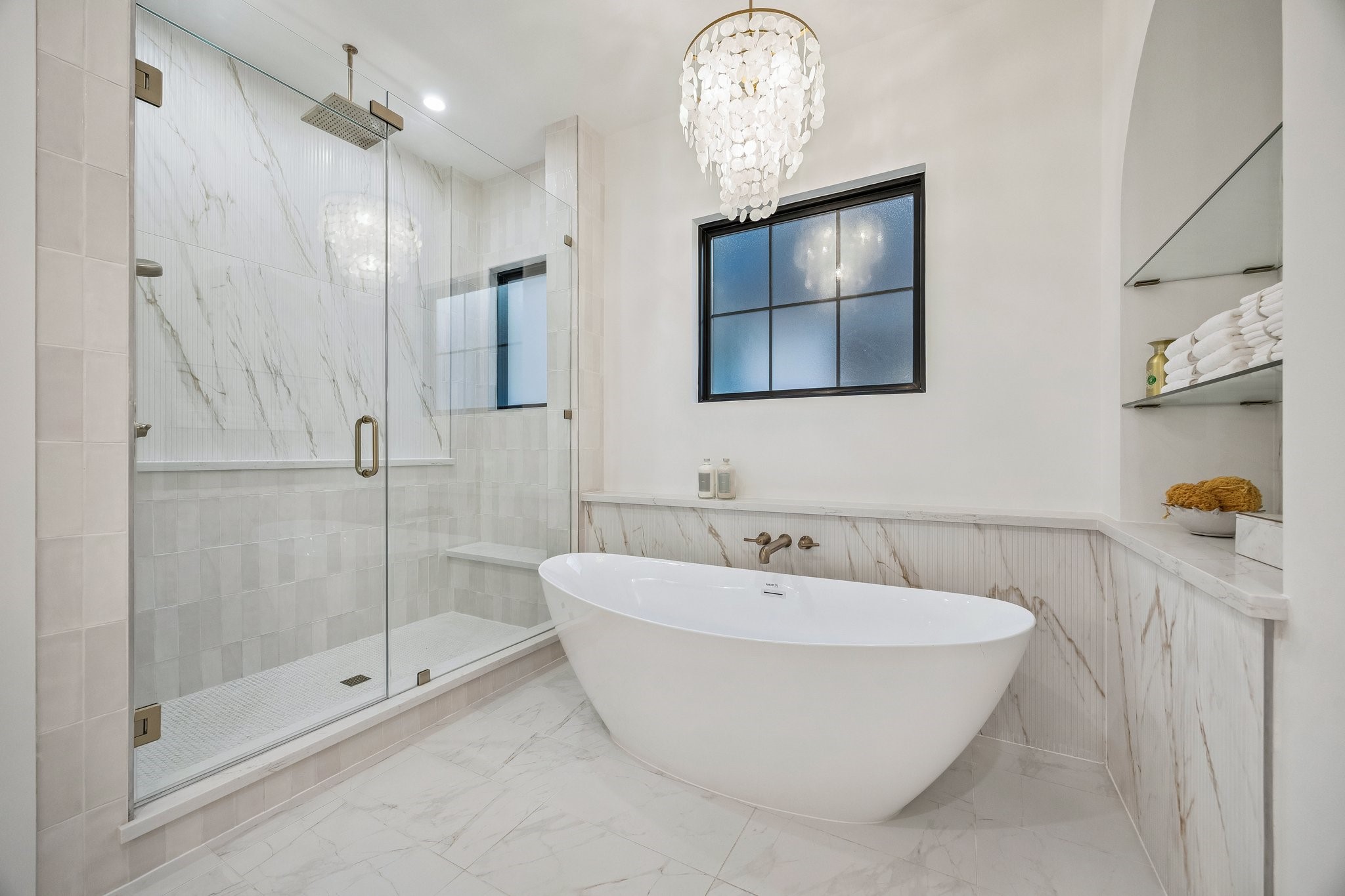 4034 Lanark Lane Houston, TX 77025 - Photo 20 of 32 Large Walk-in Shower with a Framless Shower Enclosure. The Floor in the shower is adorned with White Matt Penny Round 2 x 2 Mosaic Tile. The Shower walls are a mixture 3 x 9 Glazed Tile and 16 x 48 Ribbed Urbanslat Marmi Gold Tile.
