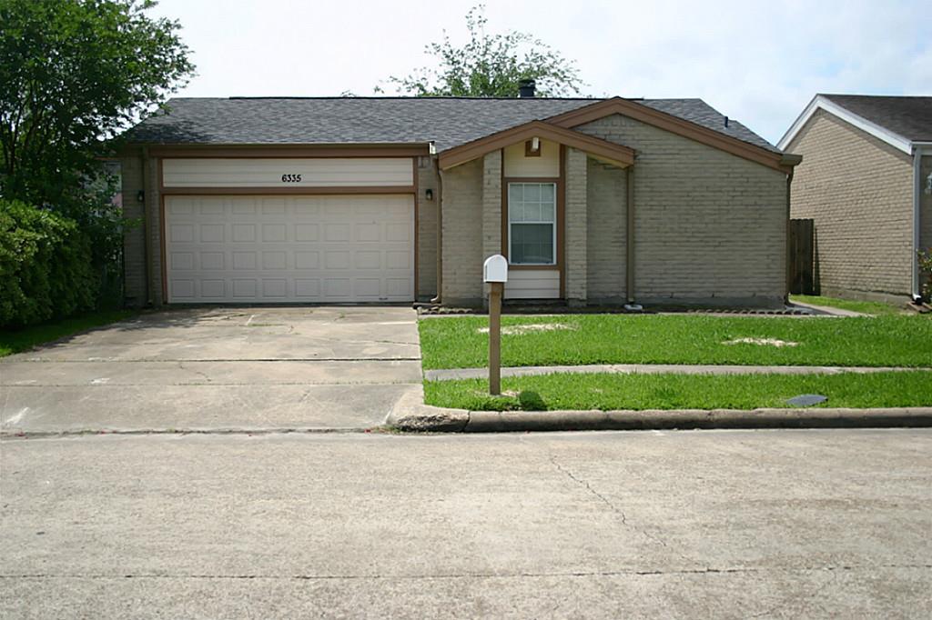 a front view of a house with a yard and a garage