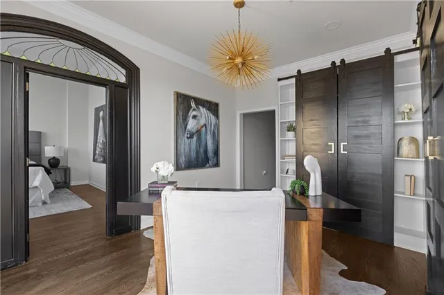 a view of a hallway with wooden floor and a large mirror